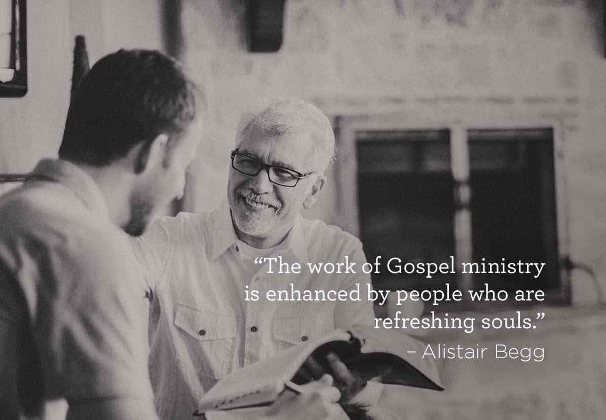 Photo of a pastor and another man smiling with an open Bible